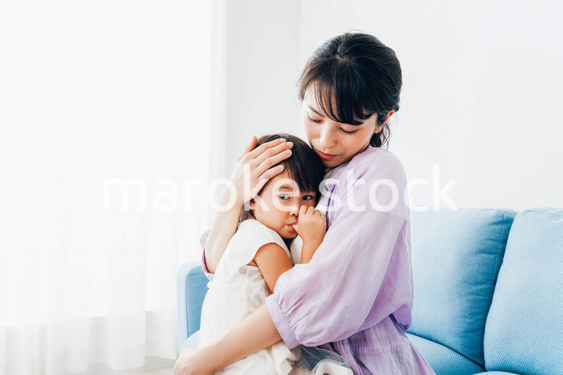 泣く子供の面倒をみるお母さん