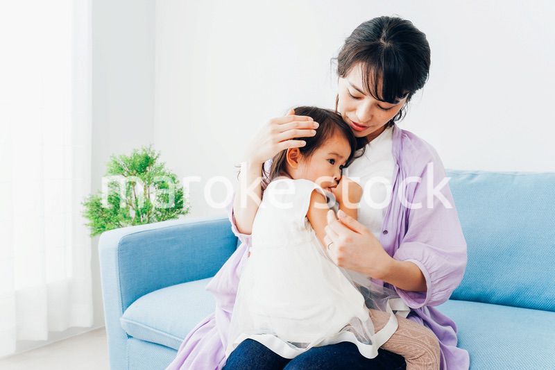 泣く子供の面倒をみるお母さん