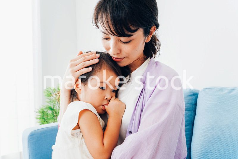 泣く子供の面倒をみるお母さん