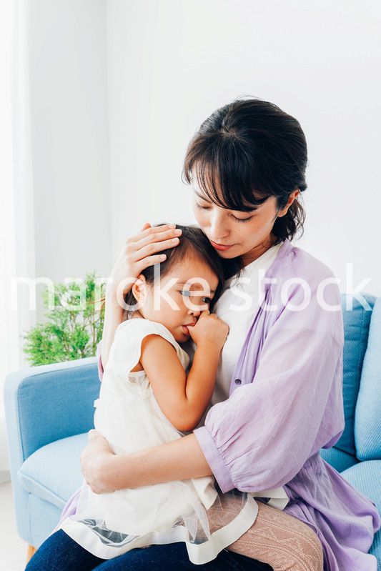 泣く子供の面倒をみるお母さん