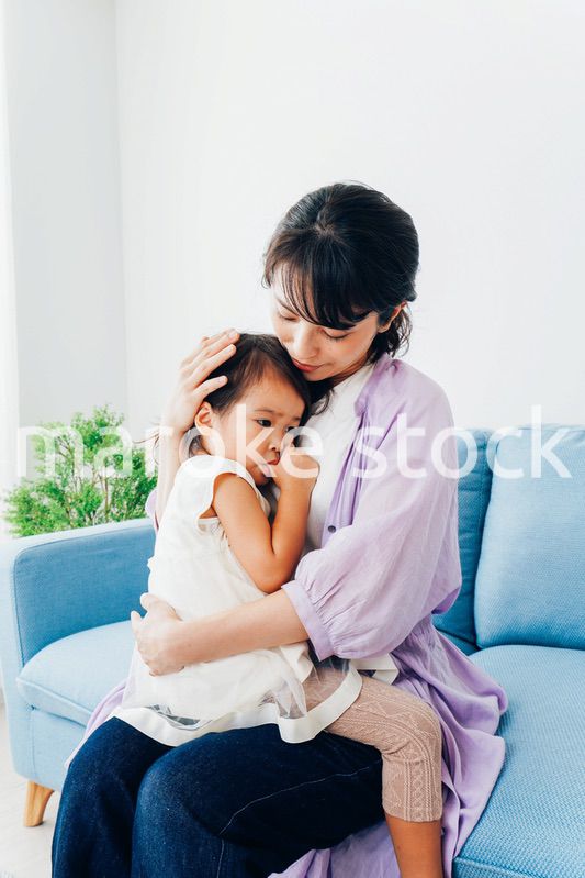 泣く子供の面倒をみるお母さん