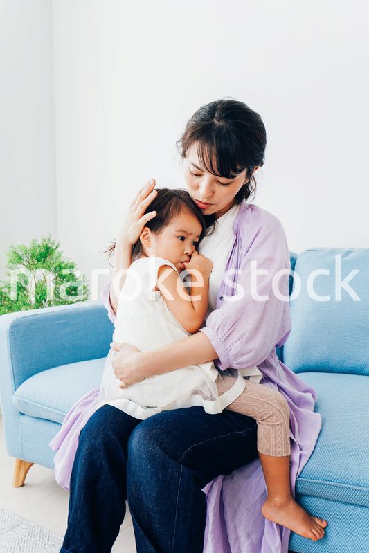 泣く子供の面倒をみるお母さん