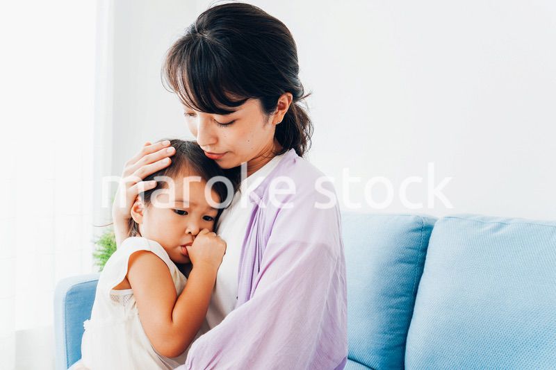 泣く子供の面倒をみるお母さん