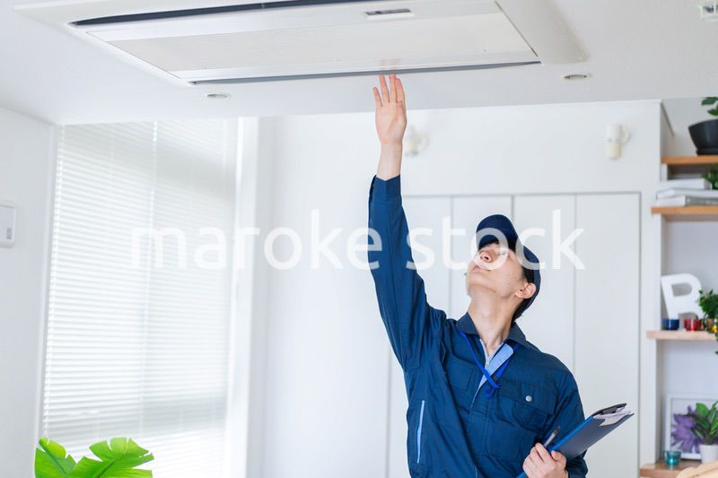 住宅の点検をする作業服の男性