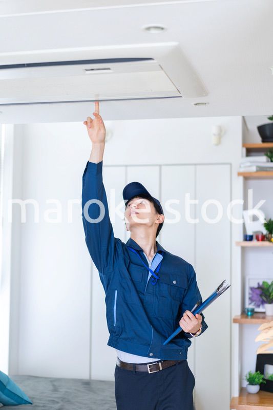 住宅の点検をする作業服の男性