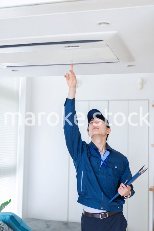 住宅の点検をする作業服の男性