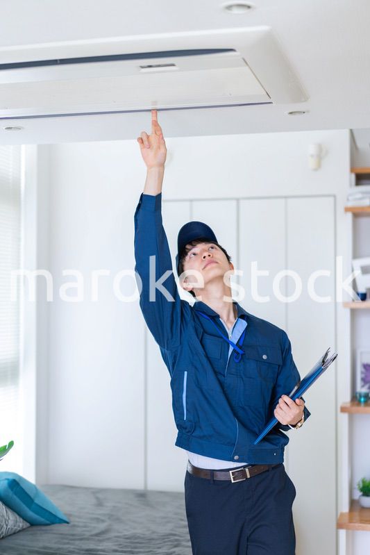 住宅の点検をする作業服の男性