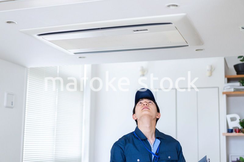 住宅の点検をする作業服の男性