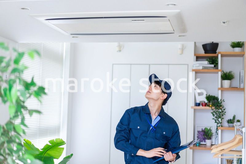 住宅の点検をする作業服の男性