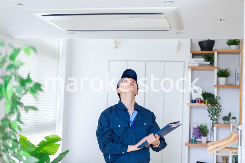 住宅の点検をする作業服の男性