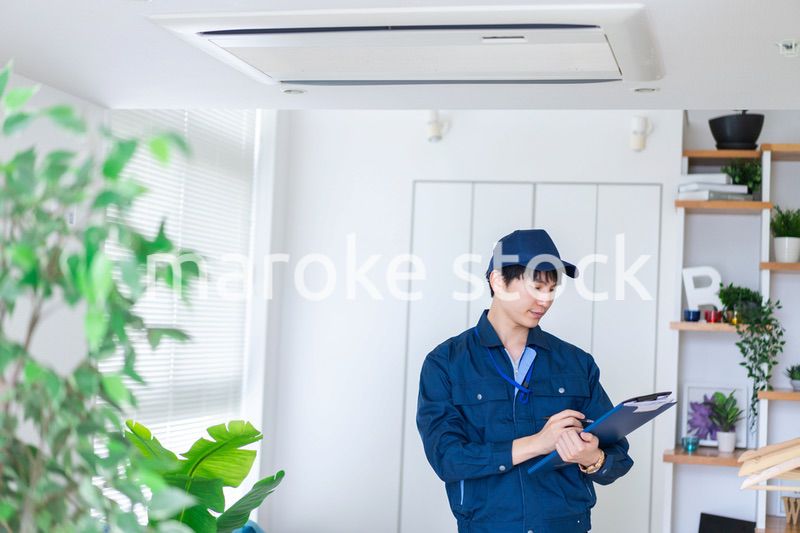 住宅の点検をする作業服の男性