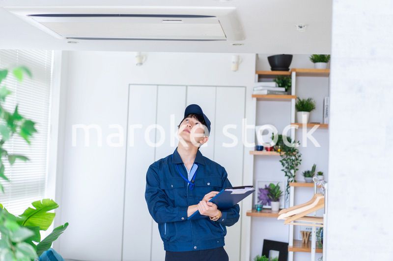 住宅の点検をする作業服の男性