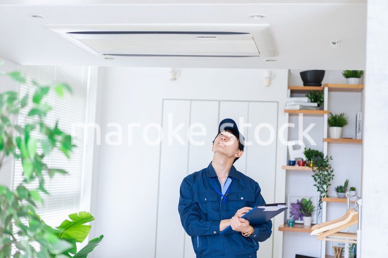 住宅の点検をする作業服の男性