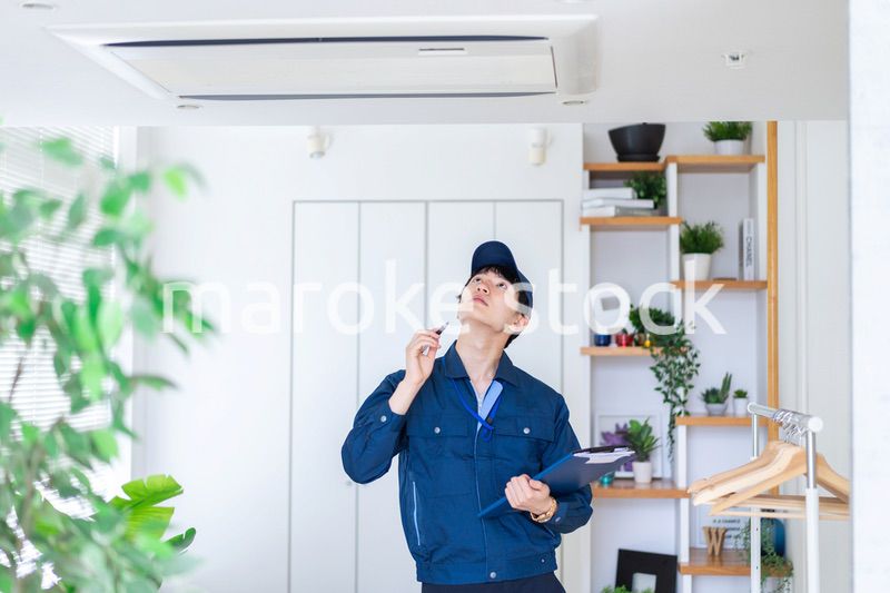 住宅の点検をする作業服の男性