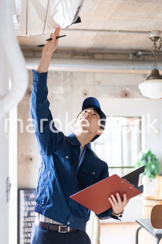 エアコンの点検をする若い作業員