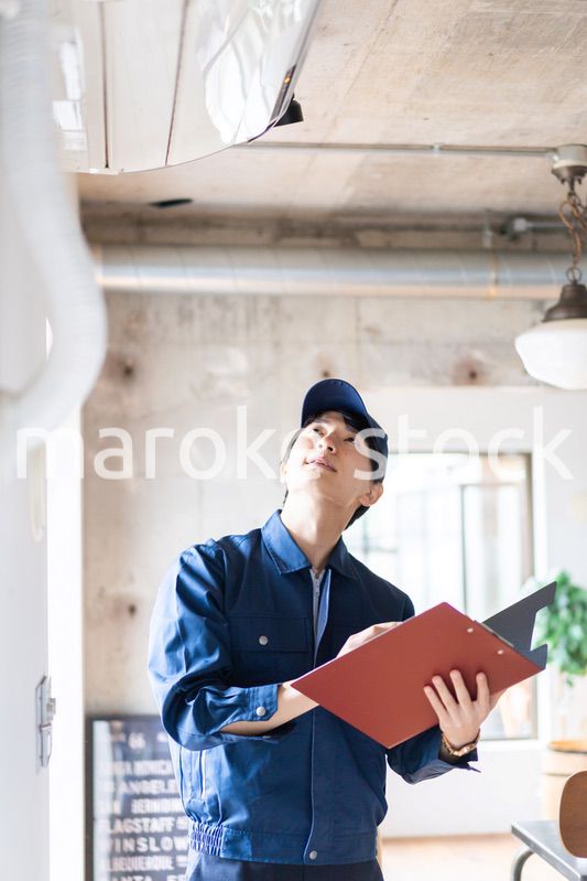 エアコンの点検をする若い作業員