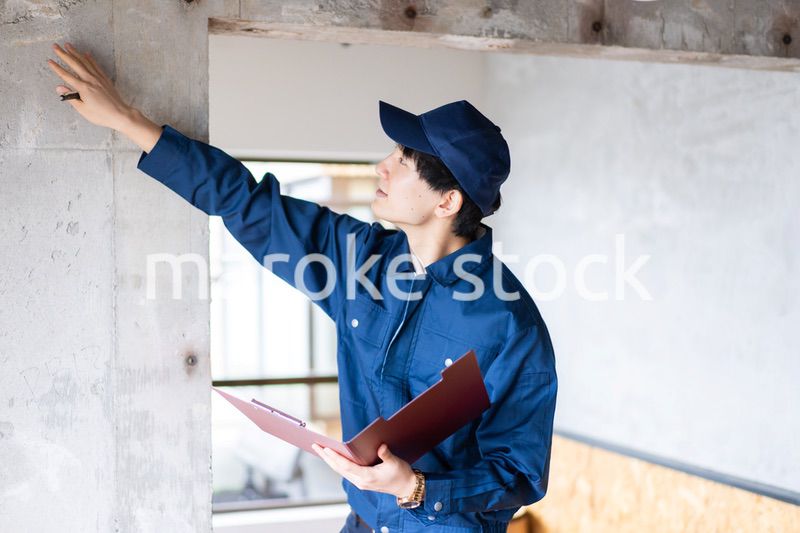 コンクリートの点検をする若い作業員