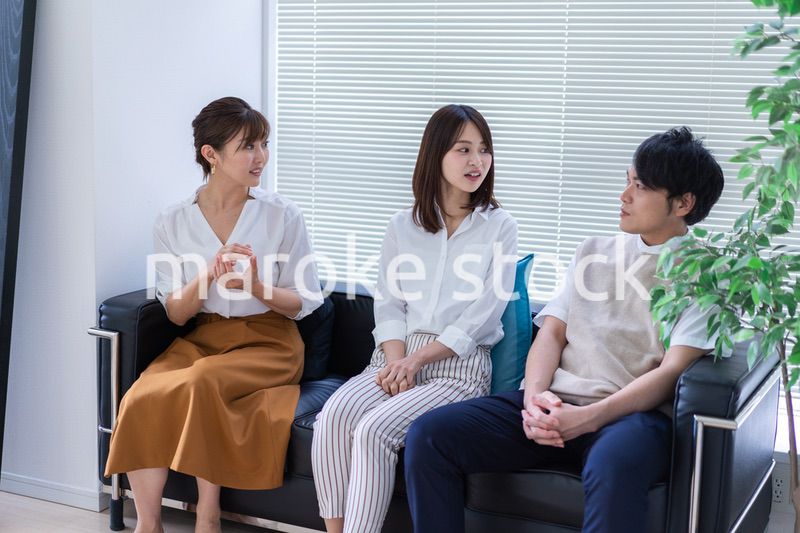 職場で楽しく話す若手会社員