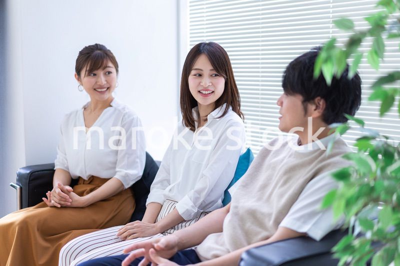 職場で楽しく話す若手会社員