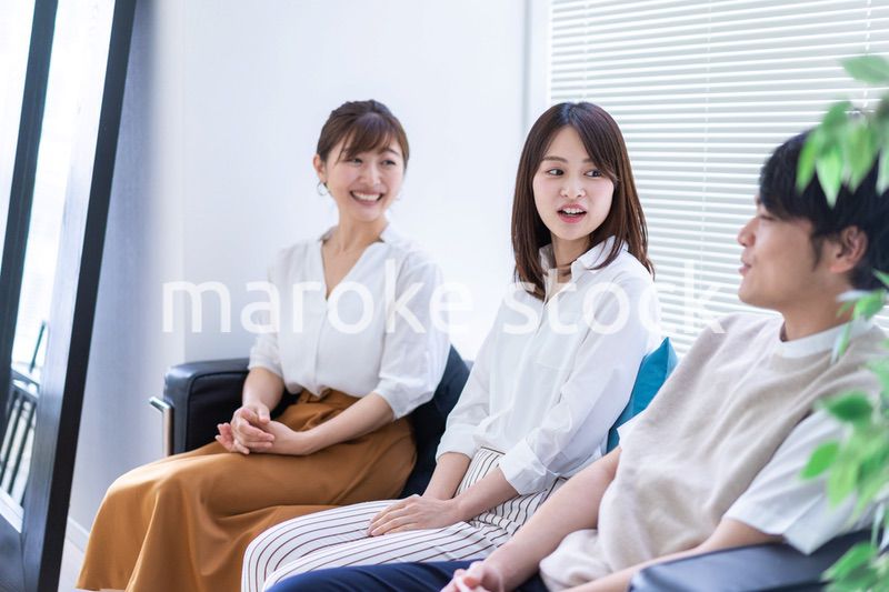 職場で楽しく話す若手会社員