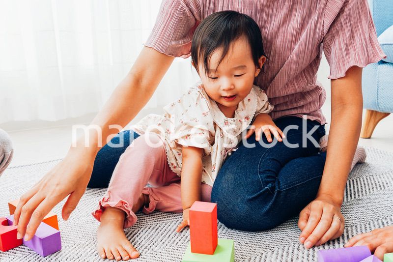 赤ちゃんと家で遊ぶお母さん