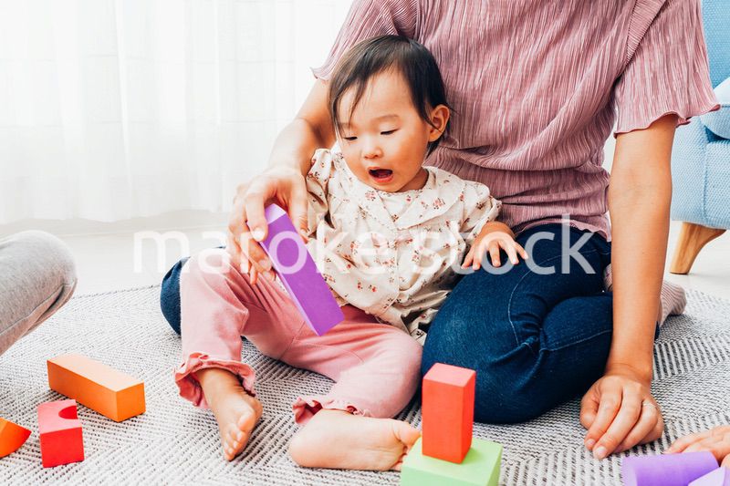 赤ちゃんと家で遊ぶお母さん