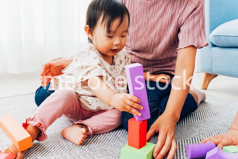 赤ちゃんと家で遊ぶお母さん