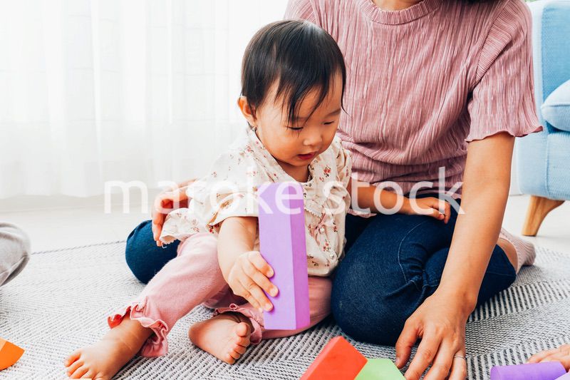 赤ちゃんと家で遊ぶお母さん