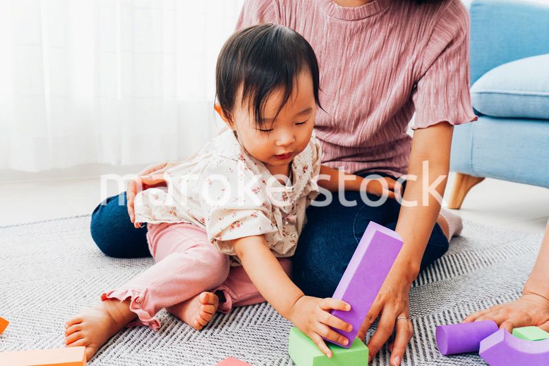 赤ちゃんと家で遊ぶお母さん