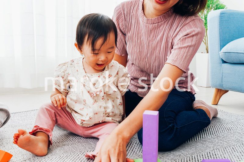 赤ちゃんと家で遊ぶお母さん