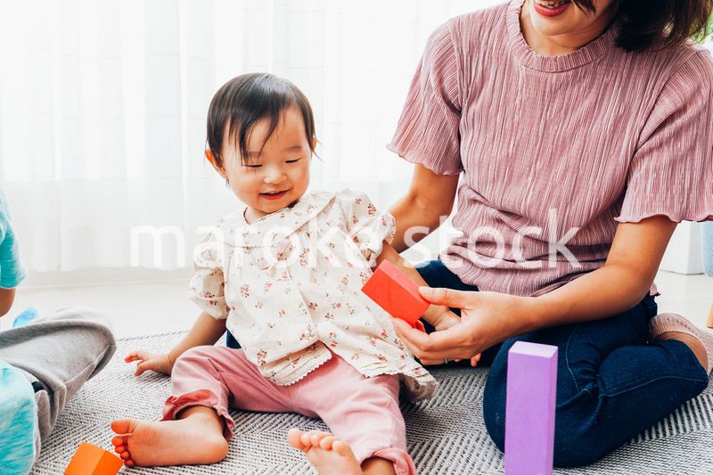 赤ちゃんと家で遊ぶお母さん