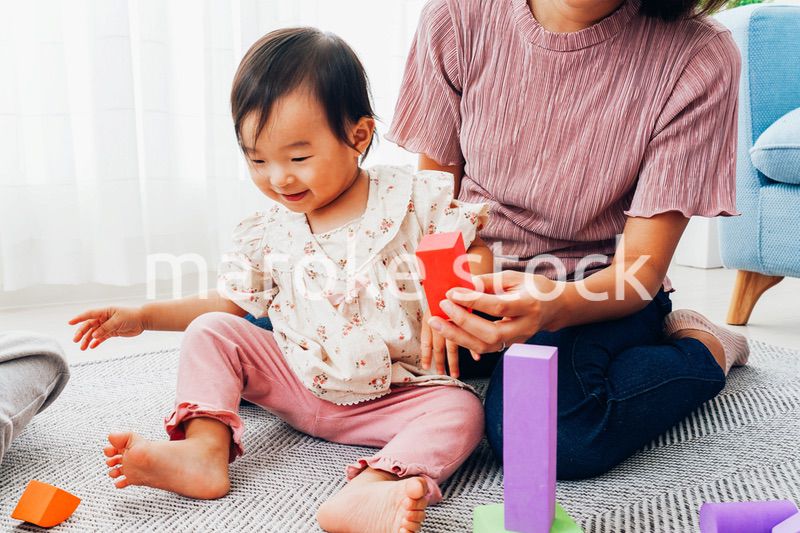 赤ちゃんと家で遊ぶお母さん