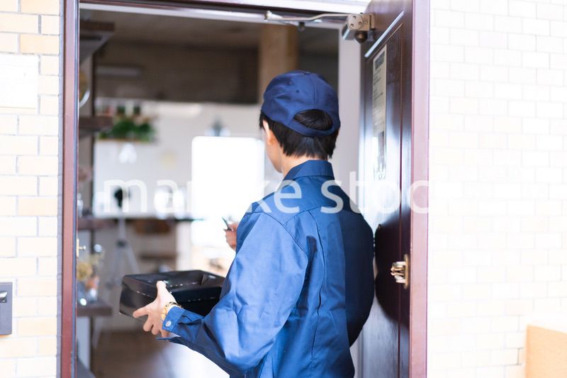 箱を配達する男性の配達員