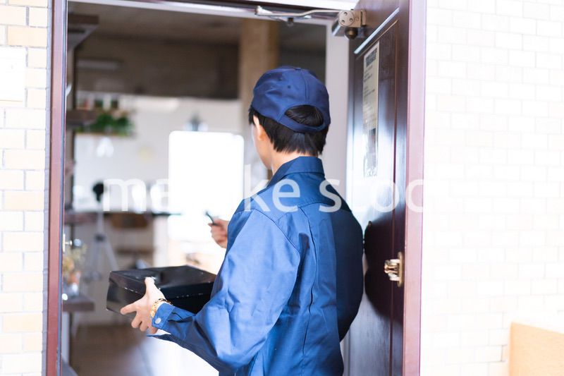 箱を配達する男性の配達員