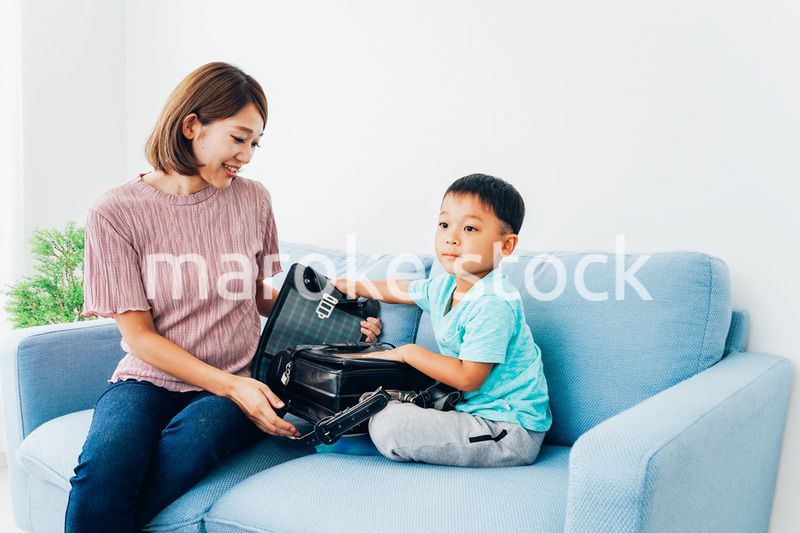 家でお母さんと話す小学生の男の子