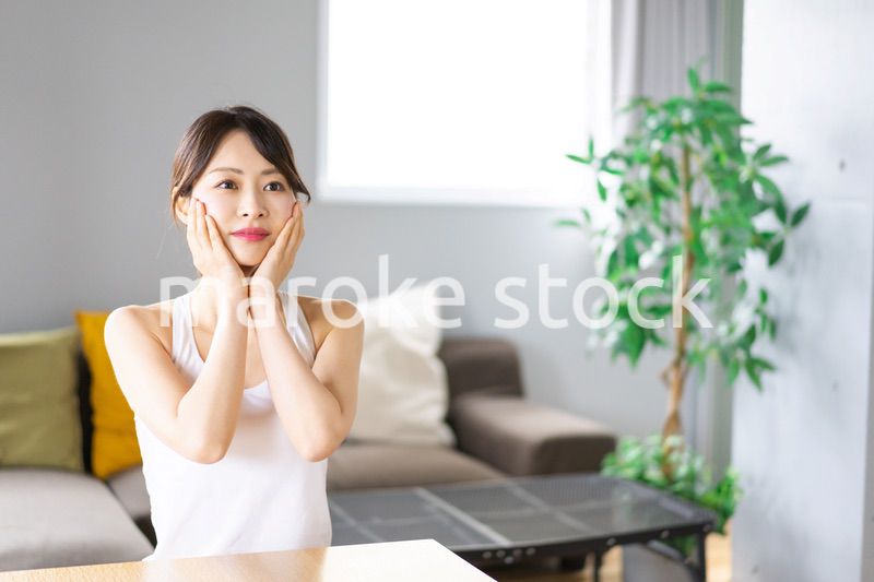 部屋でスキンケアをする若い女性