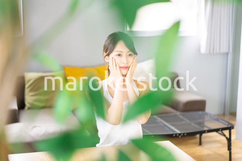 部屋でスキンケアをする若い女性