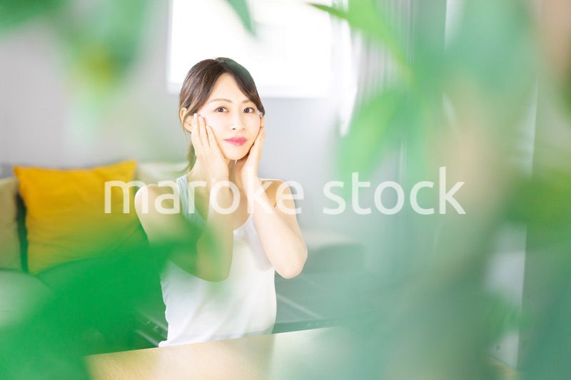 部屋でスキンケアをする若い女性
