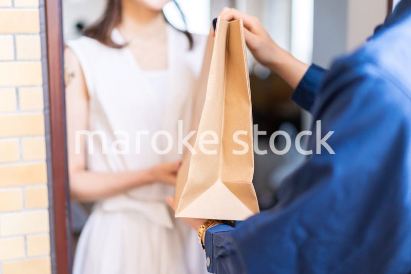 フードデリバリーを受け取る若い女性