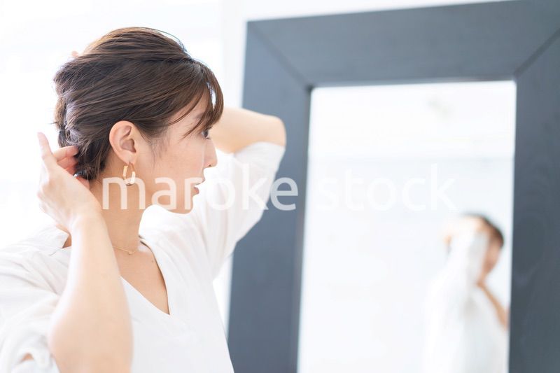 自宅でヘアスタイルを整える若い女性