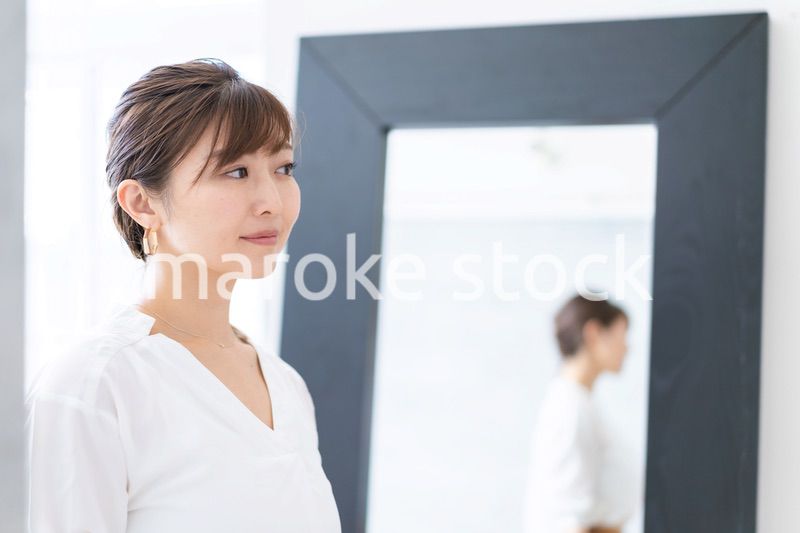 自宅でヘアスタイルを整える若い女性