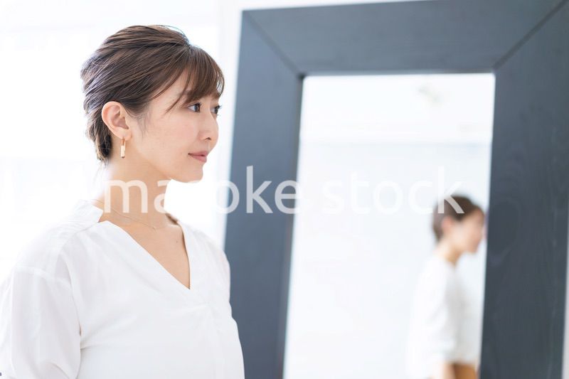 自宅でヘアスタイルを整える若い女性