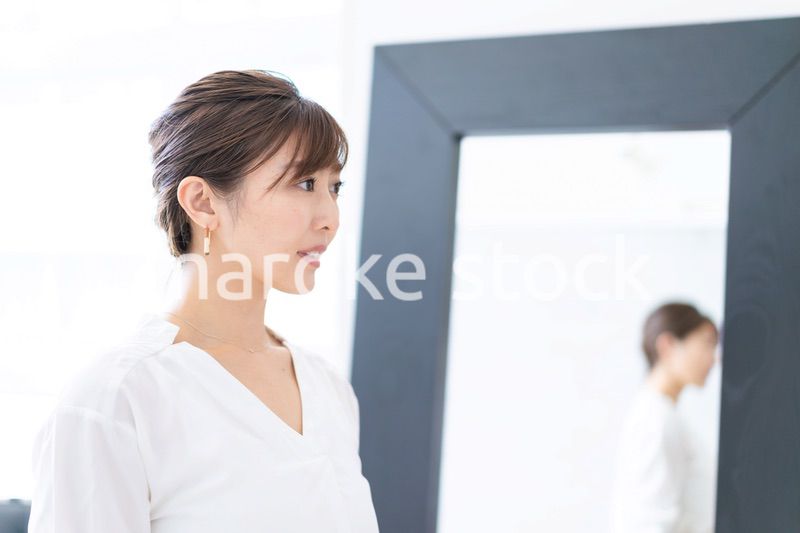 自宅でヘアスタイルを整える若い女性