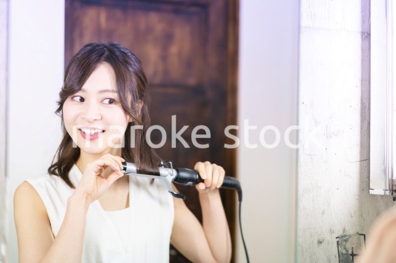 ヘアスタイルのセットをする若い女性