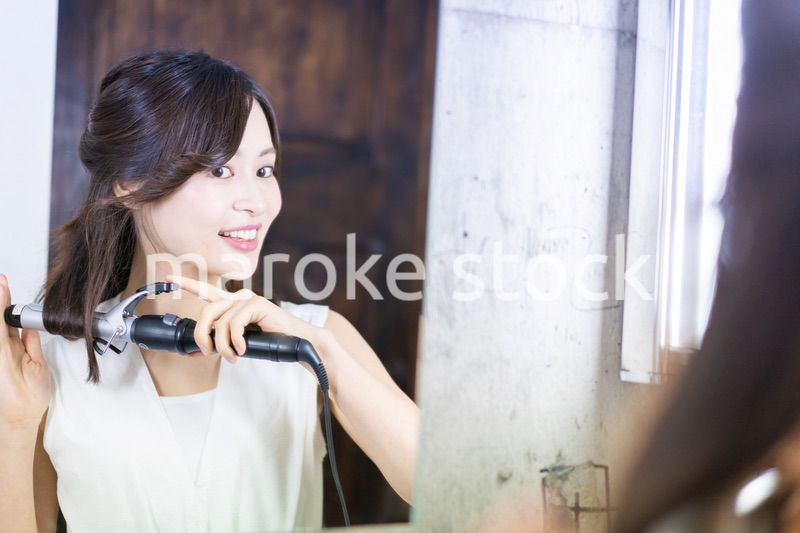 ヘアスタイルのセットをする若い女性