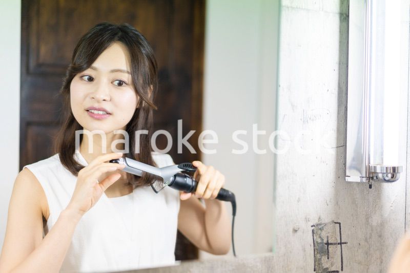 ヘアスタイルのセットをする若い女性