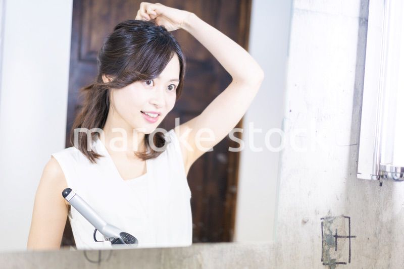 ヘアスタイルのセットをする若い女性