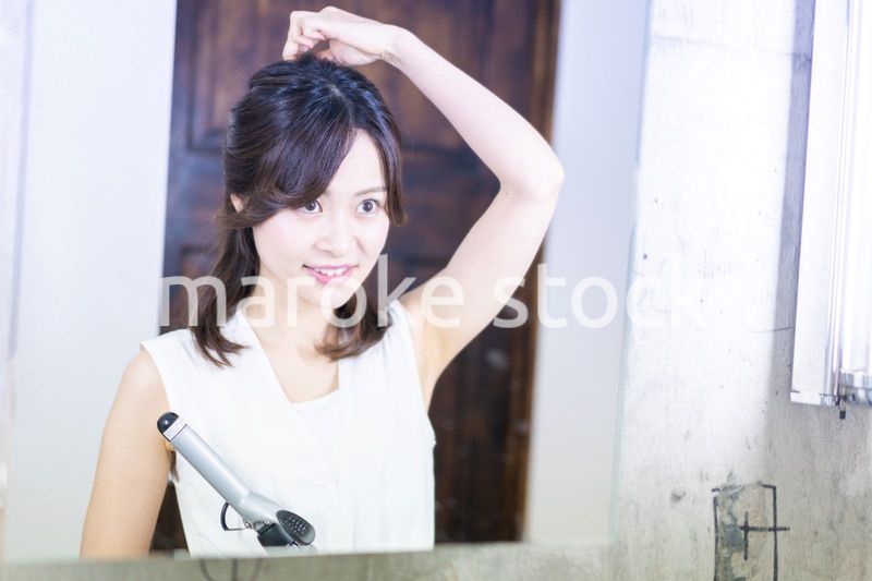 ヘアスタイルのセットをする若い女性