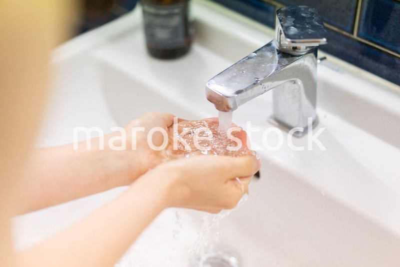 洗面所で洗顔をする若い女性