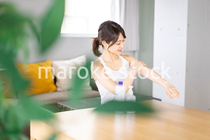 腕にクリームを塗る若い女性